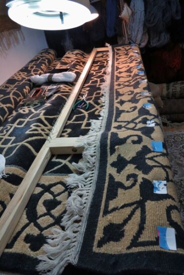 Brzeg dywanu nabity na ramę do renowacji frędzli