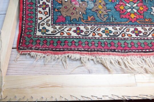 Lewa strona dywanu z uszkodzonymi frędzlami