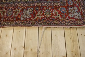 Brzeg dywanu przed naprawą